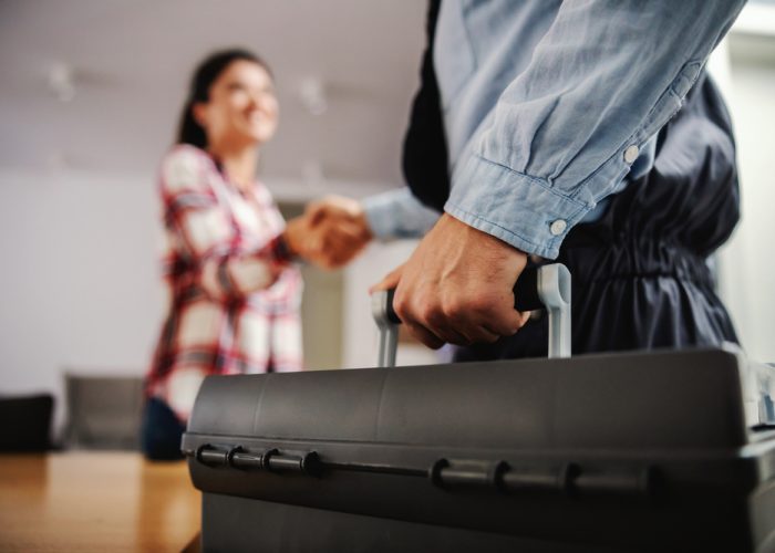 Woman,Shaking,Hands,With,A,Repairman,While,Standing,At,Home.